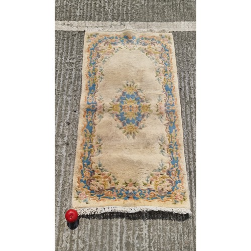 845 - A traditional style Chinese  wool rug in tones of cream, blues, greens and pinks. Measure 175 x 72 c... 