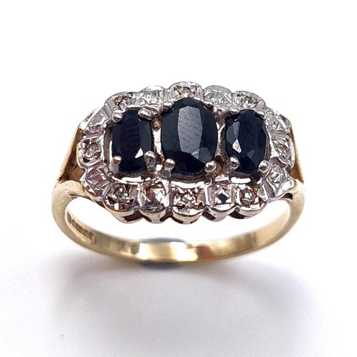 4 - Star lot : A most attractive three stone sapphire ring with diamond surround mounted in nine carat g... 