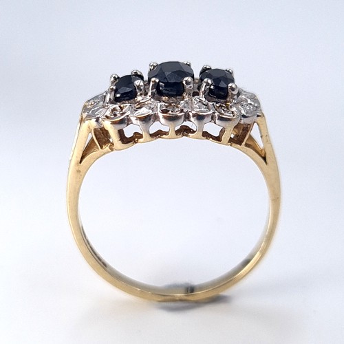 4 - Star lot : A most attractive three stone sapphire ring with diamond surround mounted in nine carat g... 