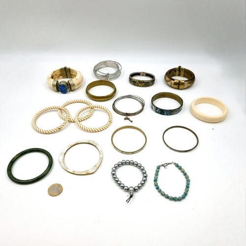 3 - A large collection of assorted bangles. Of interest a silver mounted example with bone band and Lapi... 