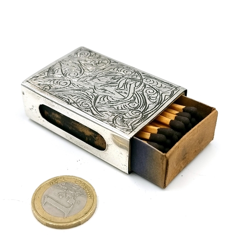 33 - An antique silver plated match box holder with incised detailing. Holder set with original box of ma... 