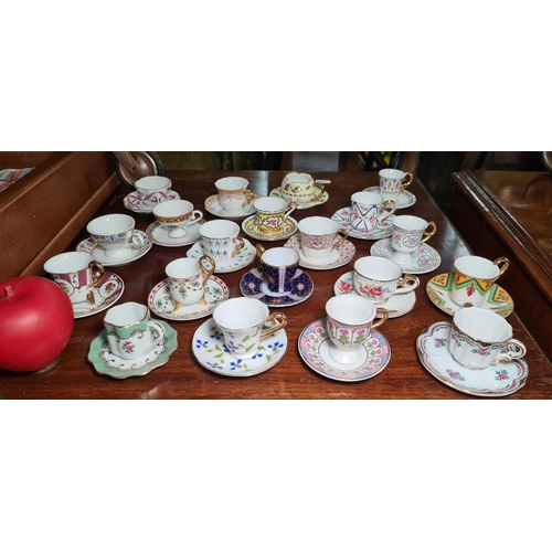 929 - Forty gorgeous pieces of delicate porcelain comprising of miniature cups and saucers all decorated i... 