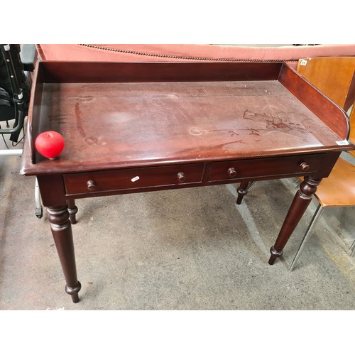 878 - A beautiful mahogany writing desk featuring tapered legs, a gallery back and two neatly sized pull o... 