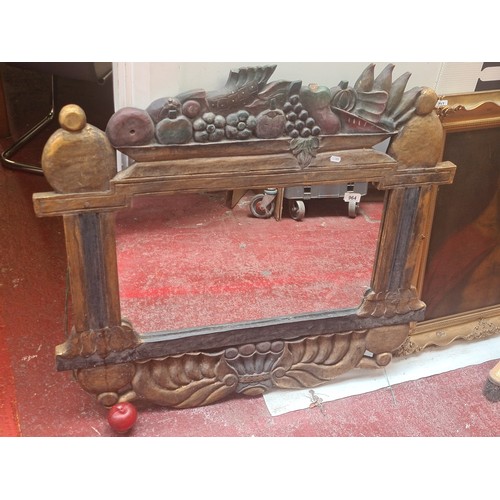 964 - A striking large solid wooden over mantle mirror featuring a carved fruit basket to top. few losses