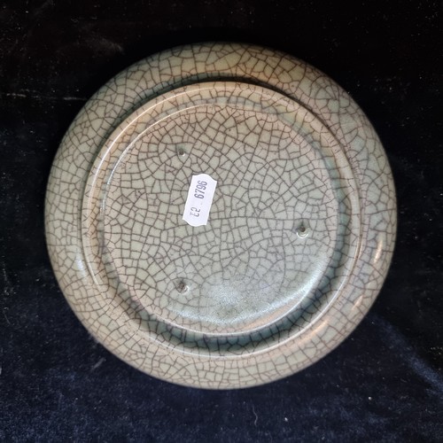 148 - An antique Chinese crackle glaze ceramic dish with two dragon like motifs in relief. Footrim shows w... 