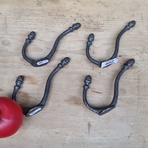 402 - Set of four metal hooks with twisted details and rounded finials.