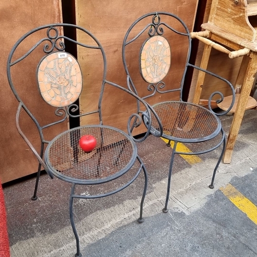 418 - Pair of wrought iron garden chairs with terracotta mosaic backs featuring a floral design.