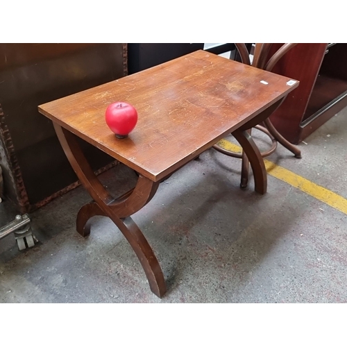 441 - A vintage coffee table with curved X frame legs .