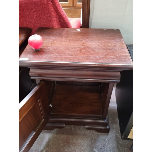 448 - A Mahogany bedside cabinet with paneled door. It features a bevelled top and stepped base. Hidden dr... 