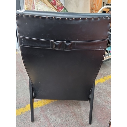 453 - Star Lot : A handsome iconic 1970's black vinyl leather armchair with chequerboard padded seat and b... 