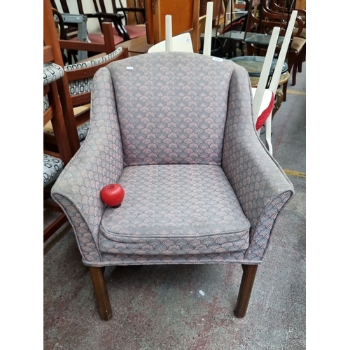 456 - A lovely upholstered armchair with patterned fabric and wooden legs, featuring a classic design.