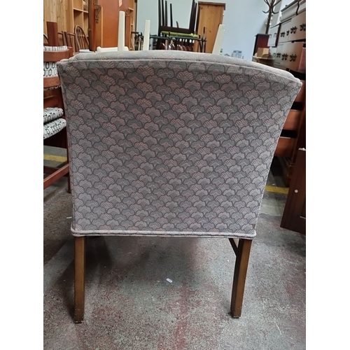 456 - A lovely upholstered armchair with patterned fabric and wooden legs, featuring a classic design.