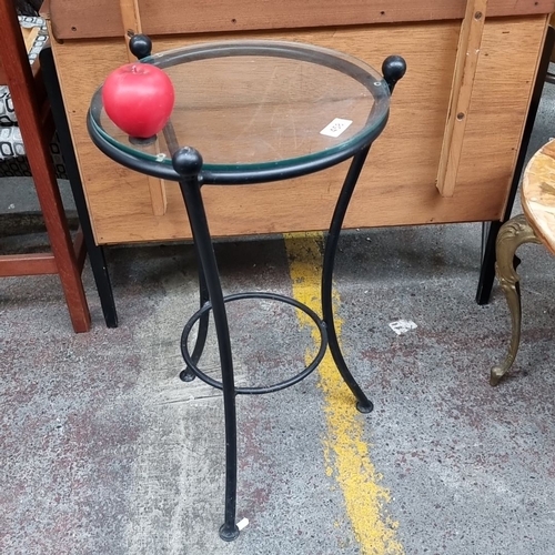 458 - Circular glass-top side table / plant stand with a heavy black wrought iron metal base.