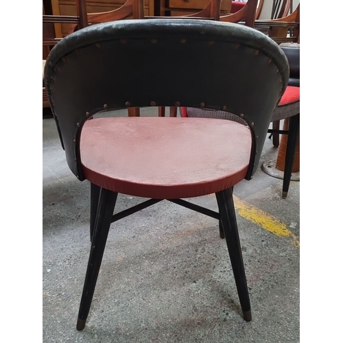 468 - Star Lot : A Mid-Century Modern chair after Antonin Suman featuring a black backrest, red seat, and ... 