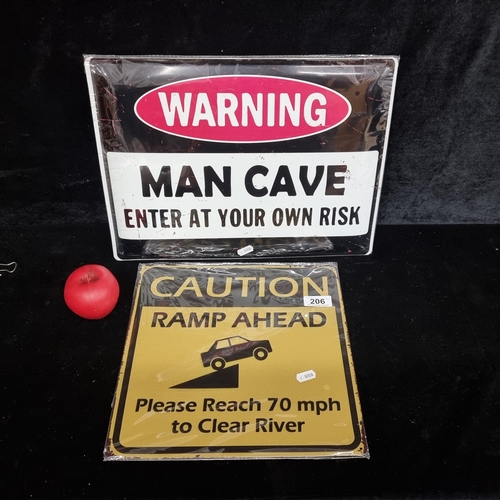 206 - Two printed metal wall signs including 'Man Cave' and 'Caution, Ramp Ahead'.