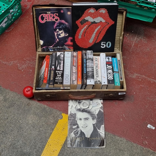 295 - A vintage leather handled suitcase containing quality hard and paper back books of rock music / band... 