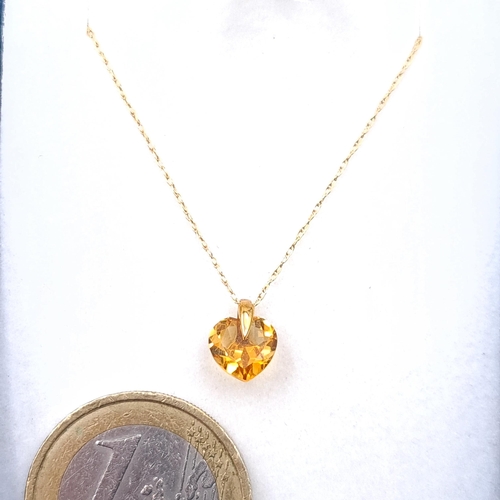 11 - A 9ct gold  heart design citrine stone pendant set with gold chain. Length - 42 cms. Boxed.