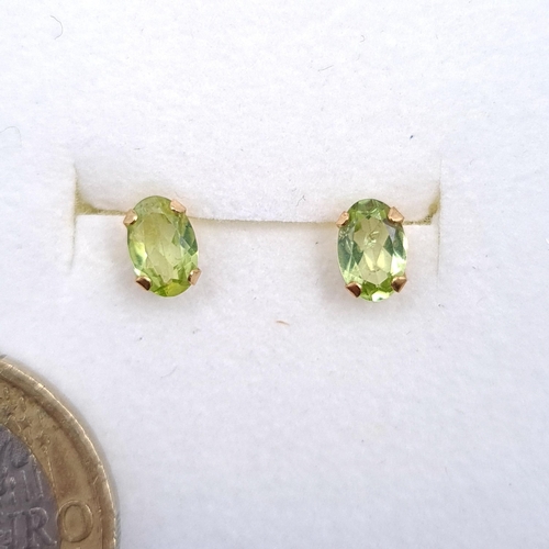 14 - A pair of nine carat gold Peridot stone stud earrings. Boxed.