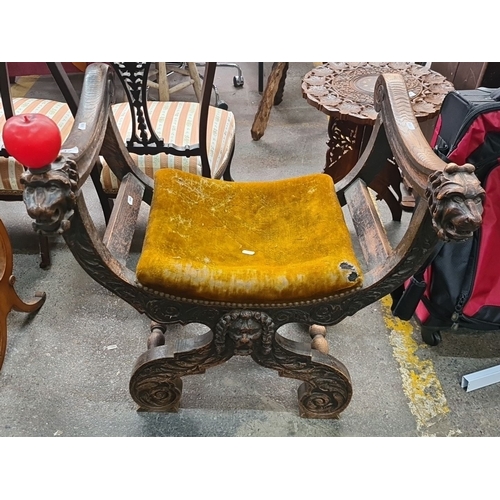 Star Lot : A 19th century Carved oak chair with lion-head armrests and golden velvet cushion, from the Victorian era.