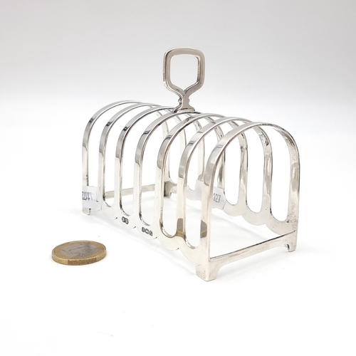 1037 - Star Lot : A sterling silver six slice toast rack with hallmarks for Birmingham dating to 1931. Leng... 