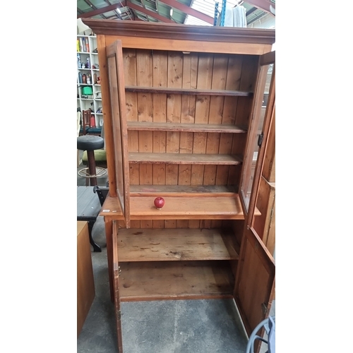 1026 - Star lot : Wooden display cabinet with upper glass-paneled doors and lower wooden doors. The cabinet... 