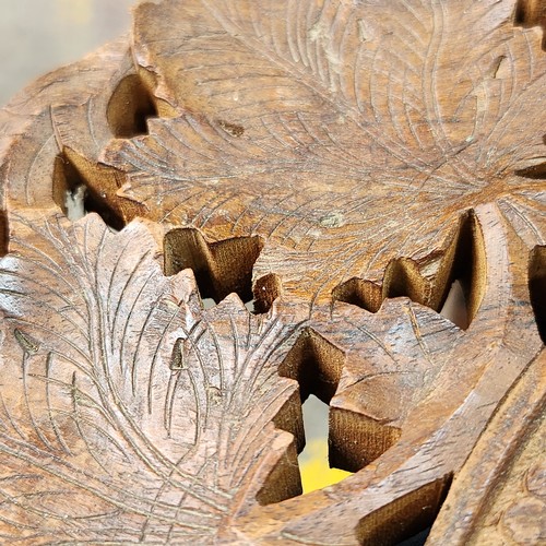 474 - An elaborately Hand-carved Indian wooden folding table with intricate floral leaf designs and a cent... 