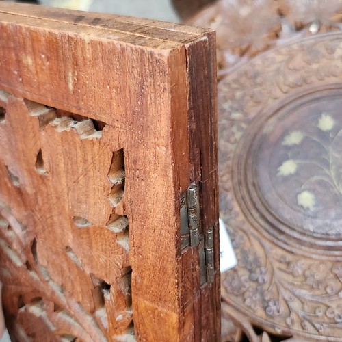 474 - An elaborately Hand-carved Indian wooden folding table with intricate floral leaf designs and a cent... 