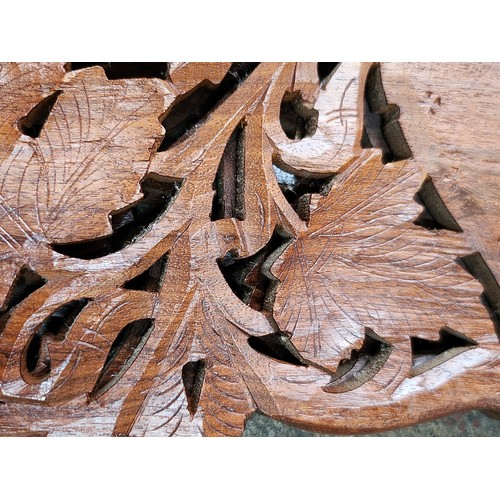 474 - An elaborately Hand-carved Indian wooden folding table with intricate floral leaf designs and a cent... 