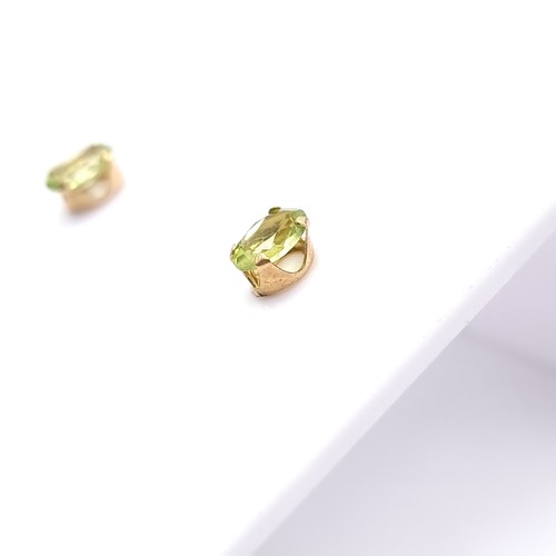 14 - A pair of nine carat gold Peridot stone stud earrings. Boxed.