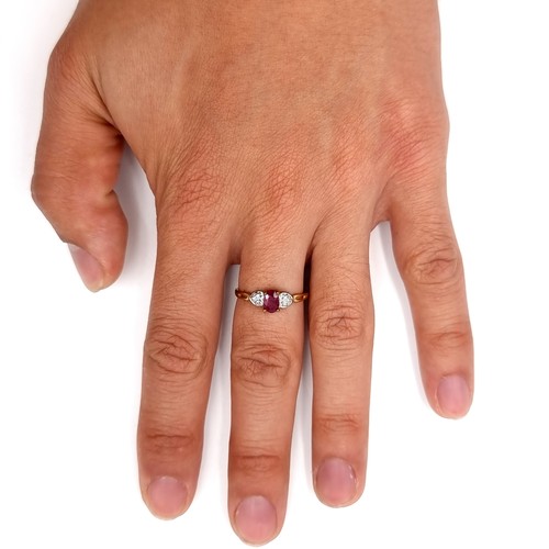 15 - Star Lot : An attractive 9ct gold metal three stone ring set with a bright ruby  stone with gem set ... 