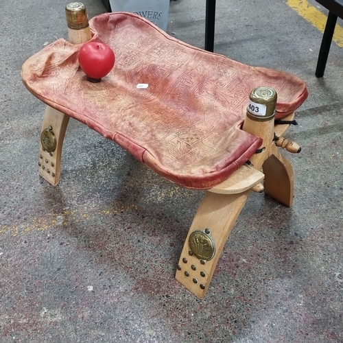 403 - Wooden stool with carved legs and an embossed leather seat featuring Egyptian motifs. Brass accents ... 