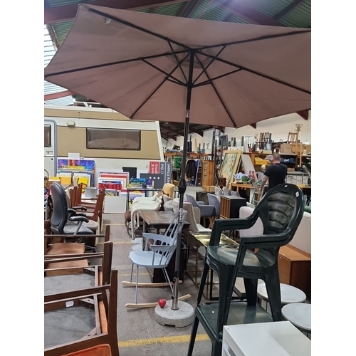 409 - Very Large outdoor patio umbrella features a sturdy base, beige canopy, and manual crank mechanism. ... 