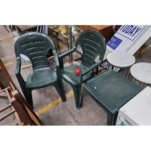 410 - This is a set of two green plastic outdoor chairs that comes with a matching square side table. They... 