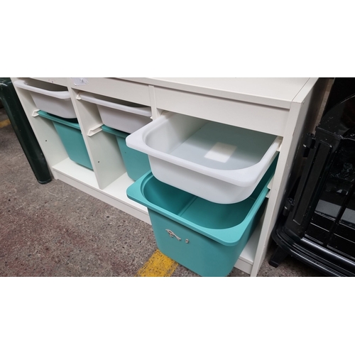 411 - White storage unit with three compartments. Each contains one white and one turquoise plastic bin. G... 