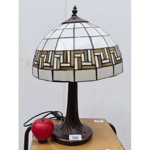 356 - A beautiful Tiffany style table lamp with a heavy base and glass shade in tones of cream and beige, ... 