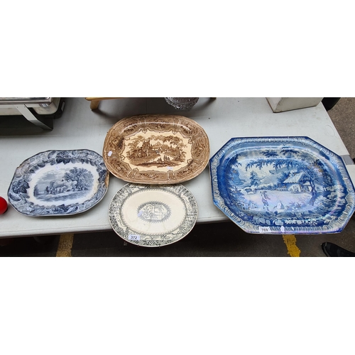 372 - An assortment of four traditional antique earthenware platters with blue and brown transferware patt... 