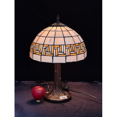 356 - A beautiful Tiffany style table lamp with a heavy base and glass shade in tones of cream and beige, ... 