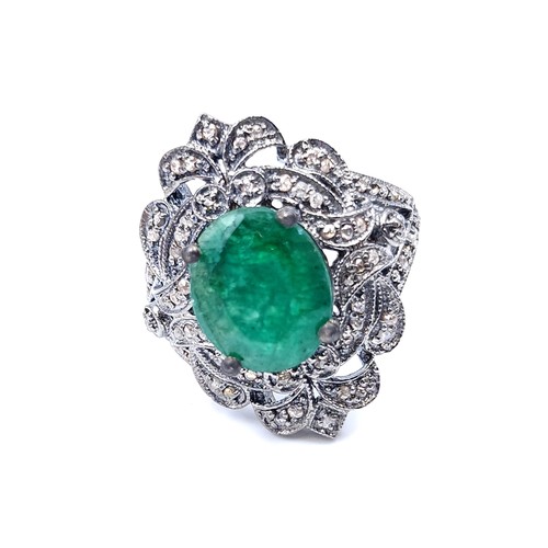 18 - Star Lot : A most attractive emerald stone ring set with a diamond foliette mount. Set in sterling s... 