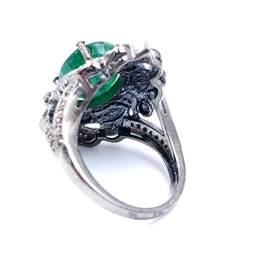 18 - Star Lot : A most attractive emerald stone ring set with a diamond foliette mount. Set in sterling s... 