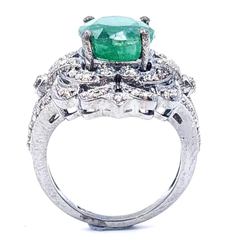 18 - Star Lot : A most attractive emerald stone ring set with a diamond foliette mount. Set in sterling s... 