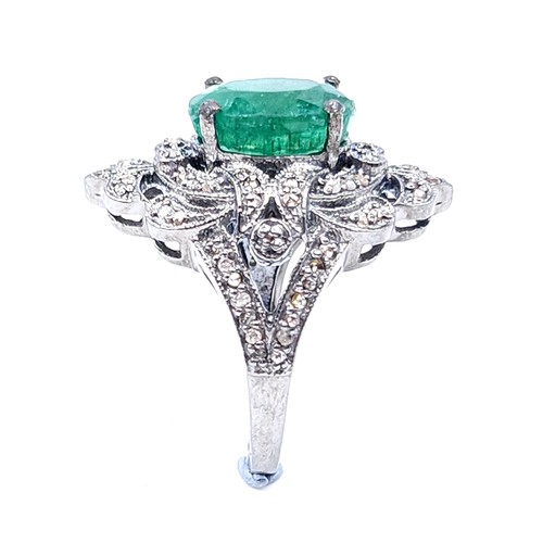 18 - Star Lot : A most attractive emerald stone ring set with a diamond foliette mount. Set in sterling s... 