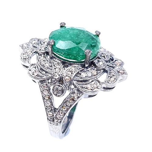 18 - Star Lot : A most attractive emerald stone ring set with a diamond foliette mount. Set in sterling s... 