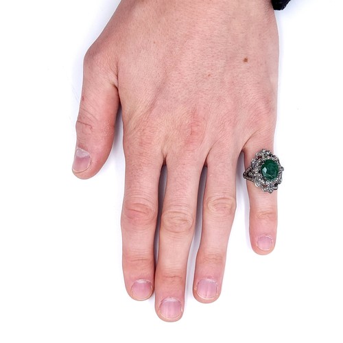 18 - Star Lot : A most attractive emerald stone ring set with a diamond foliette mount. Set in sterling s... 