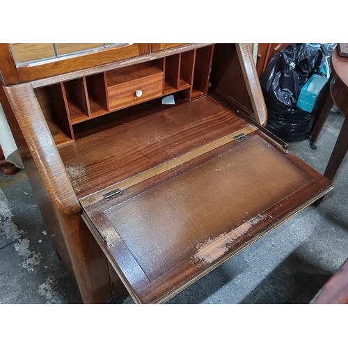 1097 - A 1940s bureau bookcase with desk and  glass display cabinet. It features leaded glass doors over a ... 