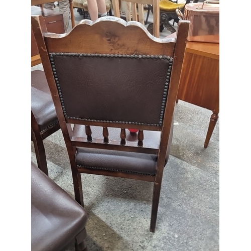 1100 - Set of four Victorian-style dining chairs with carved wooden frames and studded leather upholstery. ... 