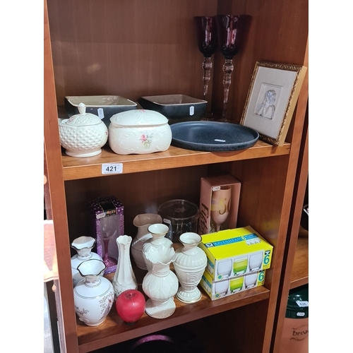 Two Shelves  of assorted ceramics and collectibles including Irish Parian Donegal China pieces, decorative vases, glassware, and framed artwork. Boxed drinking glasses.