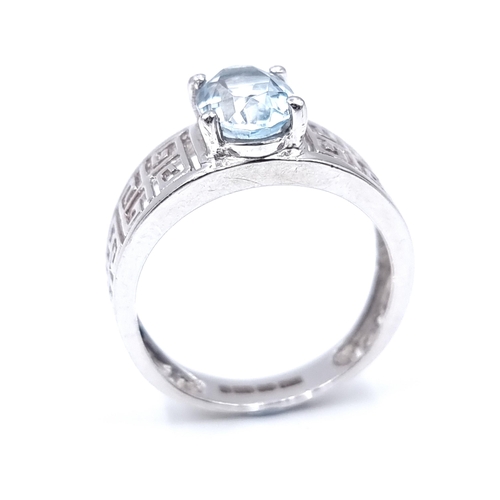 11 - A nine carat white gold topaz ring with key design shoulder. Size - L 1/2. Weight - 3 grams.