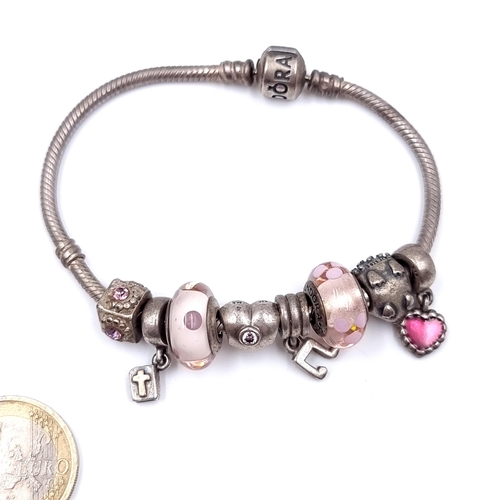 28 - A Pandora sterling silver bracelet with nine charms. Total weight - 38 grams. Comes in Pandora box.