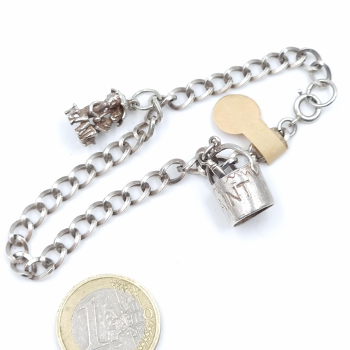 31 - A sterling silver charm bracelet set with two silver charms. Total weight - 13.2 grams.