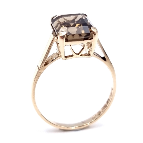 7 - Star Lot : A nine carat gold smoky quartz claw set ring. Size - M 1/2. Weight - 2.4 grams.